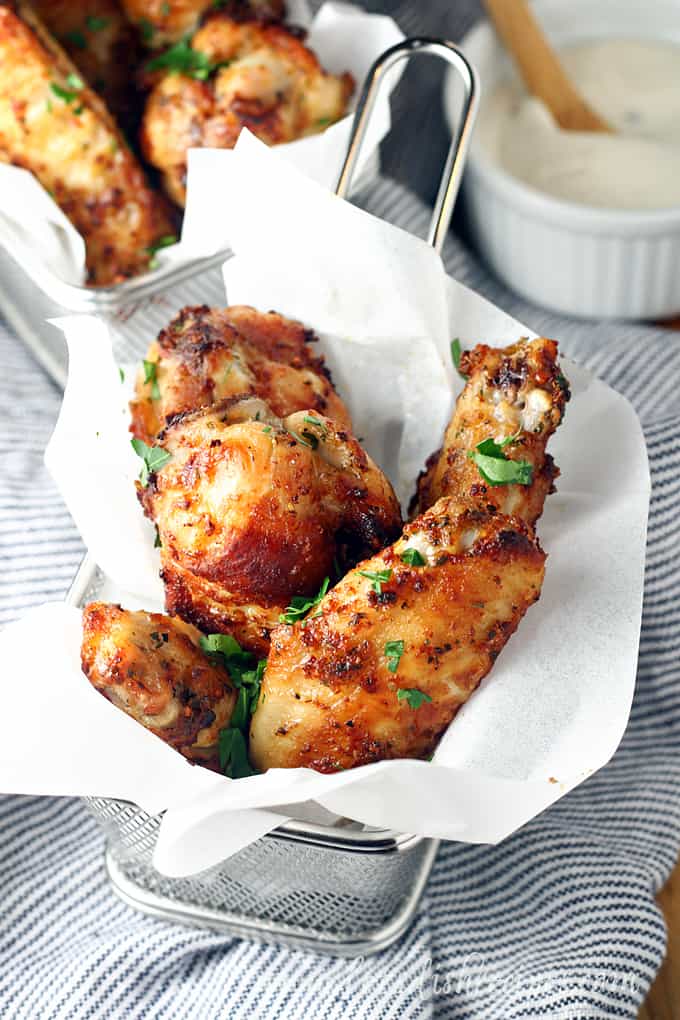 Chicken wings in a basket with parchment paper.